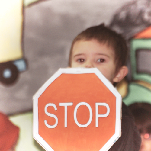 enfant tenant un panneau stop